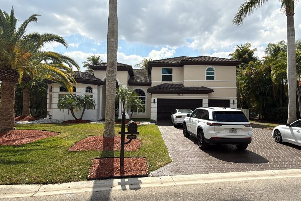 Completed tile roof on a South Florida home with palms and a paver driveway